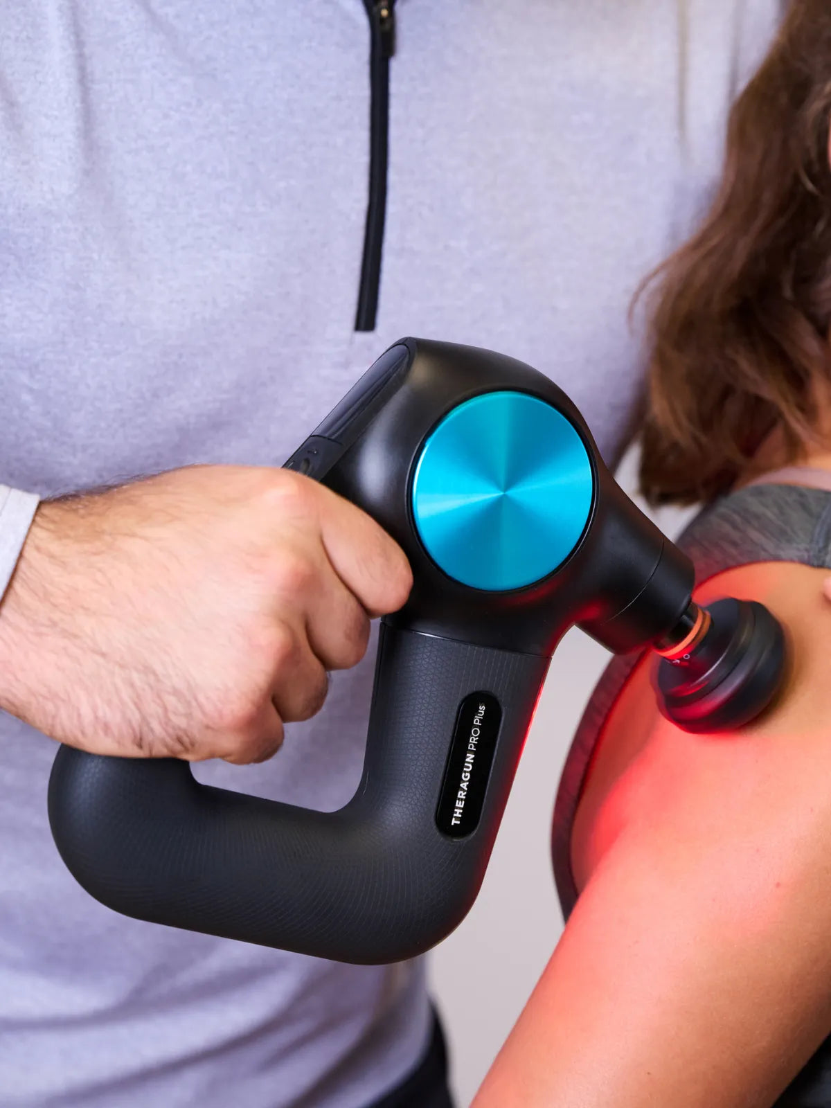 Nahaufname einer Therabody Theragun PRO Plus Massagepistole, mit der eine Person am Arm massiert wird. Mobile Image