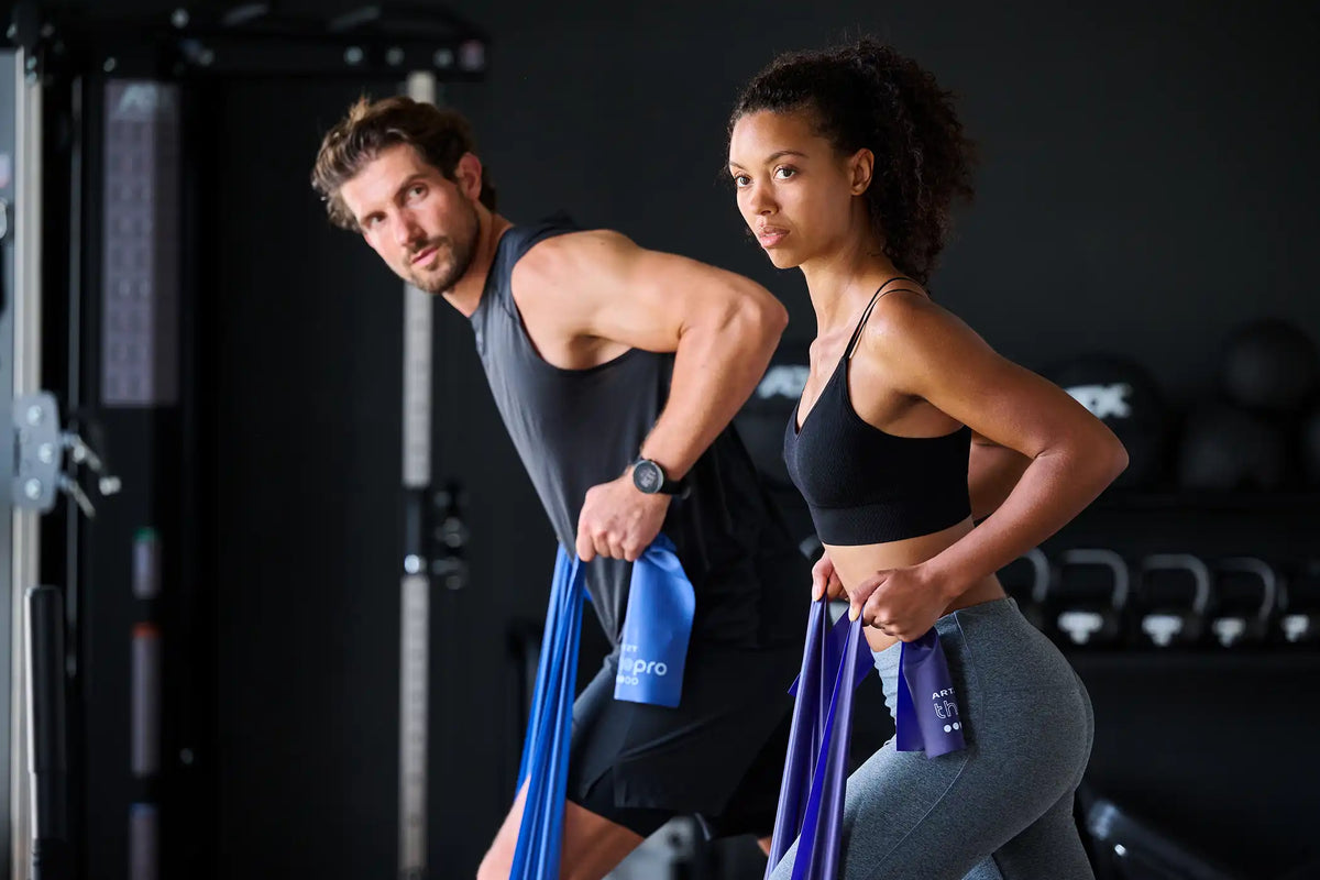 Mann und Frau trainieren jeweils mit einen ARTZT thepro Fitnessband